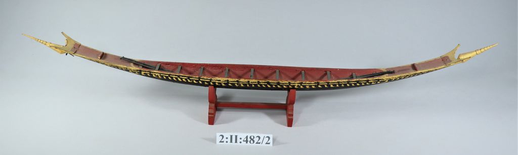 ເຮືອຊ່ວງຈໍາລອງ ເຮັດດ້ວຍໄມ້ ທານໍ້າກ້ຽງ ພອກຄໍາປີວ ມີໄມ້ພາຍ 4 ອັນ.