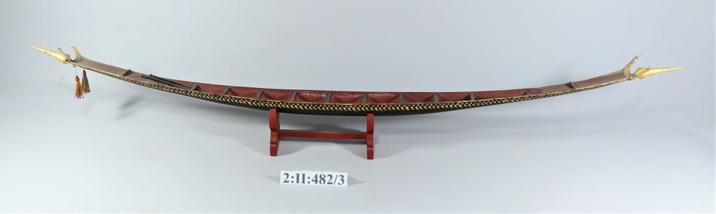 ເຮືອຊ່ວງຈໍາລອງ ເຮັດດ້ວຍໄມ້ ທານໍ້າກ້ຽງ ພອກຄໍາປີວ ມີໄມ້ພາຍ 4 ອັນ.