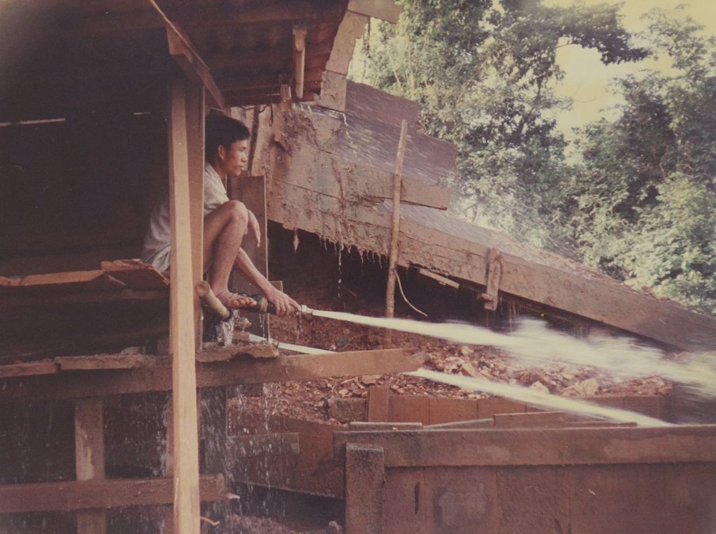 ກຳ​ມະ​ກອນ​ກຳ​ລັງ​ຊິດ​ດິນ​ແຮ່​ລົງ​ໃສ່​ຮ່າງ​ລຳ​ລຽງ​ແຮ່