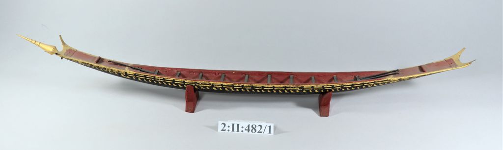 ເຮືອຊ່ວງຈໍາລອງ ເຮັດດ້ວຍໄມ້ ທານໍ້າກ້ຽງ ພອກຄໍາປີວ ມີໄມ້ພາຍ 4 ອັນ.