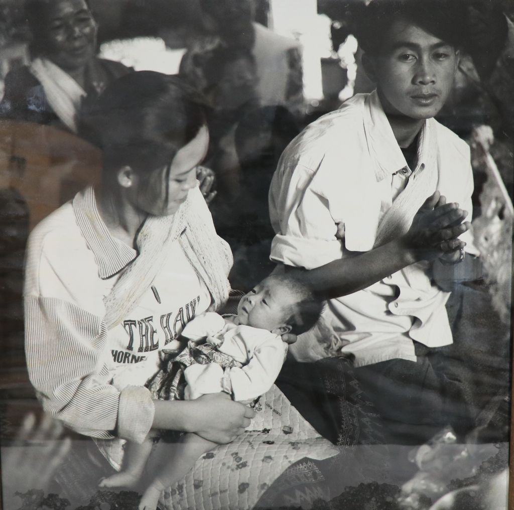 ຮູບ​ພ​າບຂາວດຳ   ແມ່ຍິງອູ້ລູກ ຜູ້ຊາຍນັ່ງນົບ ( ພິທີອອກກຳເດືອນ)