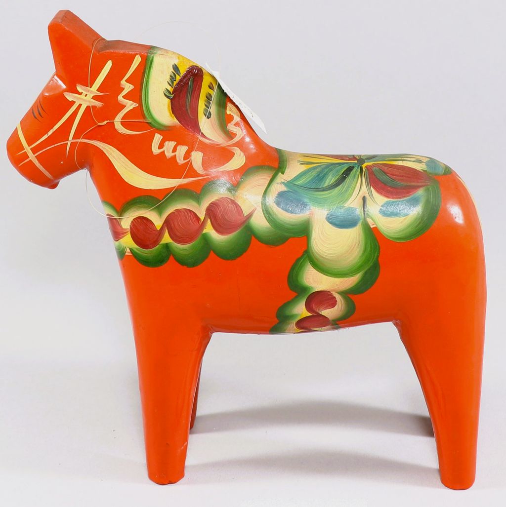 ມ້າ ເຮັດດ້ວຍໄມ້ທາສີແດງ ເທິງຫຼັງມ້າ ແຕ້ມຮູບດອກໄມ້ໃສ່