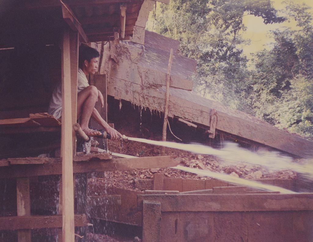 ກຳ​ມະ​ກອນ​ກຳ​ຊິດ​ນ້ຳ​ໃສ່​ແຮ່​ລົງ​ໃສ່​ຮາງ​ລຳ​ລຽງ​ແຮ່