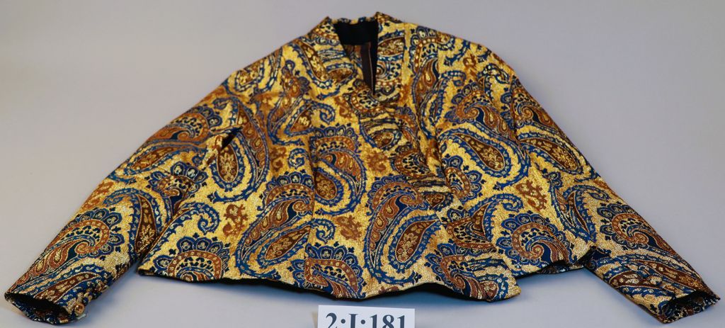 ເສື້ອຄໍປ້າຍ ຜ້າໄໝ ສີທອງ ລາຍດອກສີໝາກຄໍ.